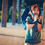 Image of a happy child carrying a backpack Image of a happy child carrying a backpack