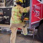 Image of a Fairview firefighter climbing into fire engine