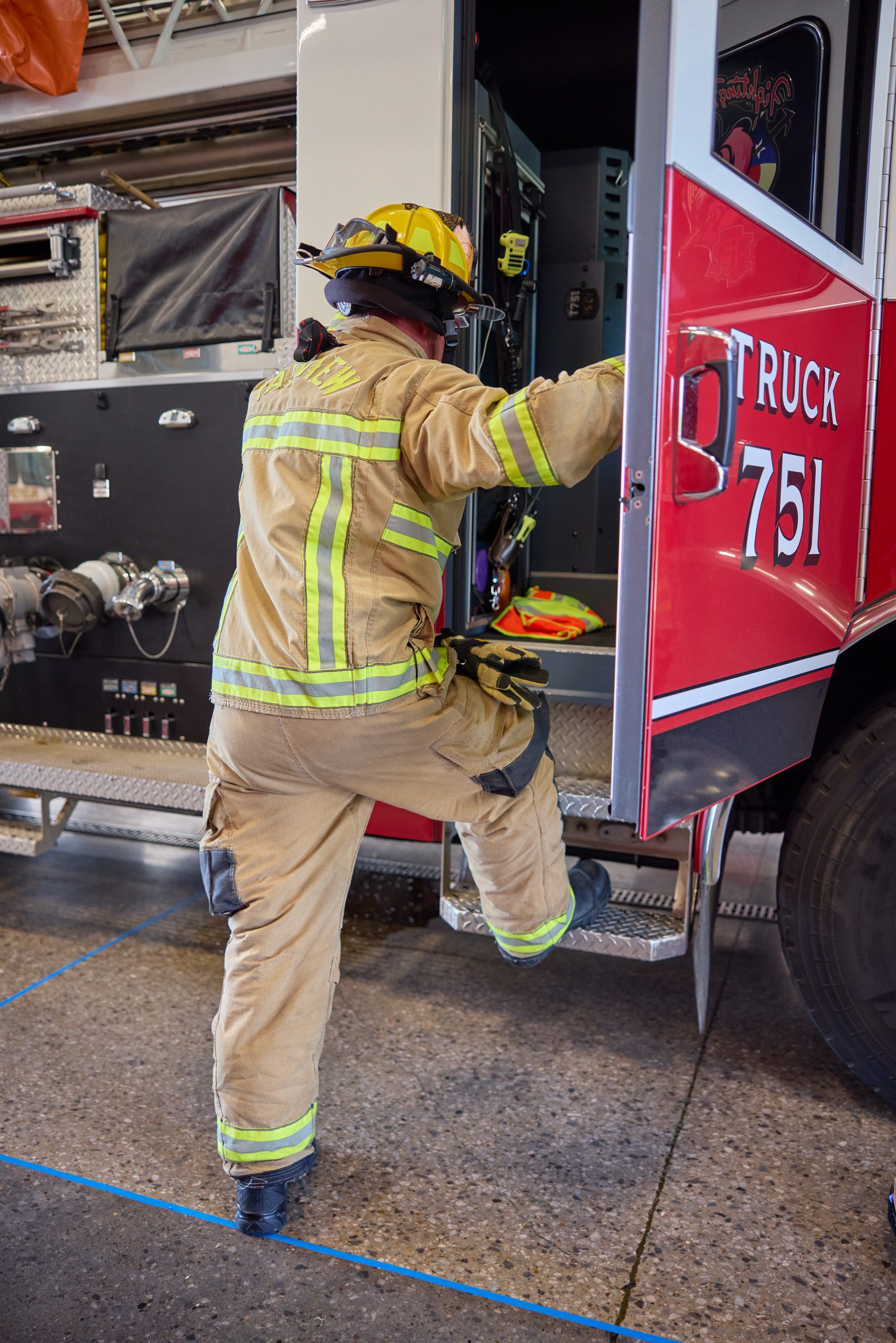 Image of a Fairview firefighter climbing into fire engine