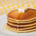 Image of a stack of pancakes with butter and syrup on a plate